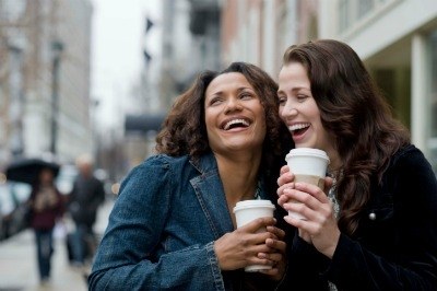 Two friends laughing together on the street